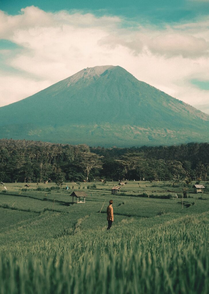pexels-photo-1694631-1694631 Tranquil scene of a mountain and lush fields with a lone person standing, capturing natural beauty.
